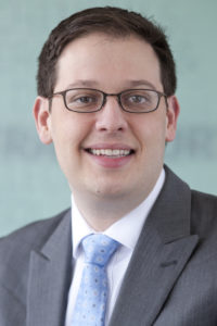 Headshot of Jeff Cohen on a light blue background